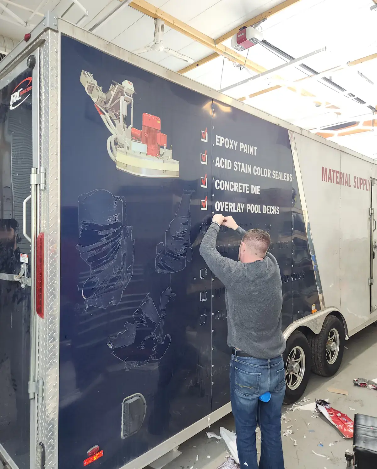 Technician removing vehicle wrap graphics from a commercial fleet van at Chicago Fleet Wraps facility